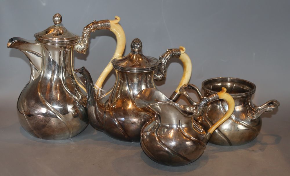 An early 20th century continental white metal four piece tea set, three with carved ivory handles, gross 53oz